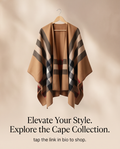 A beige open-front cape-style cardigan with a classic plaid check pattern in brown, black, white, and red, hanging on a wooden hanger against a warm beige background with soft leaf shadows. Text below reads: 'Elevate Your Style.