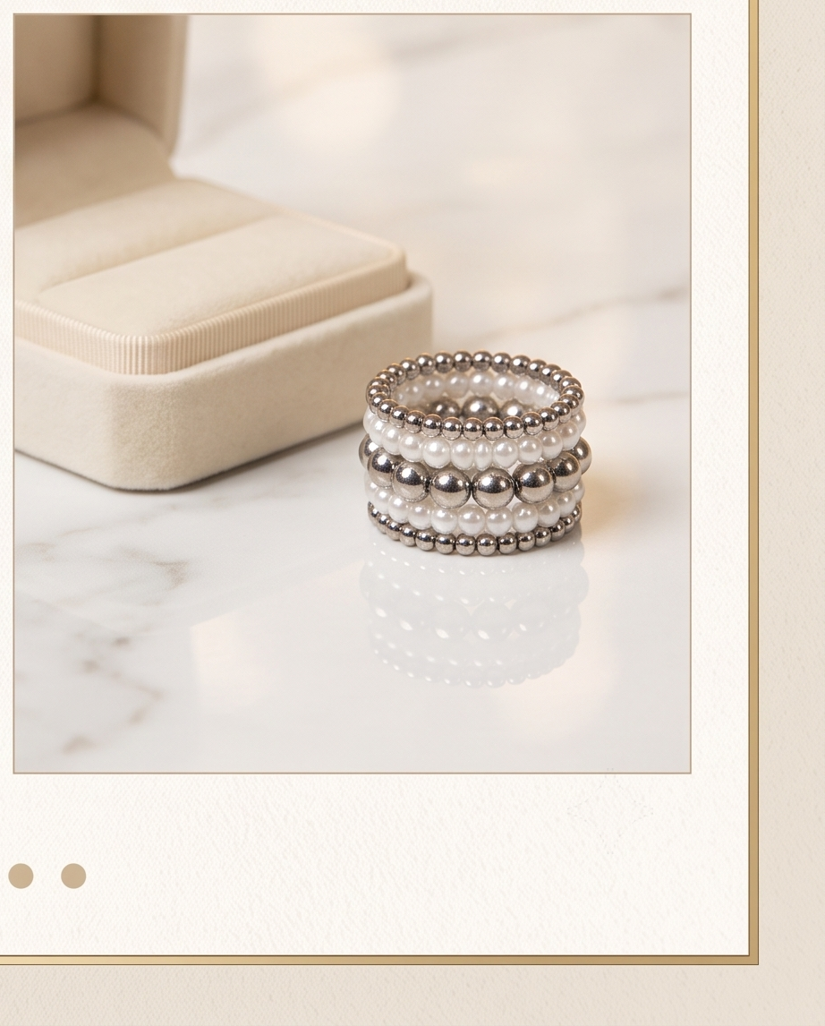 Pearl and silver bead ring set on marble surface next to jewellery box