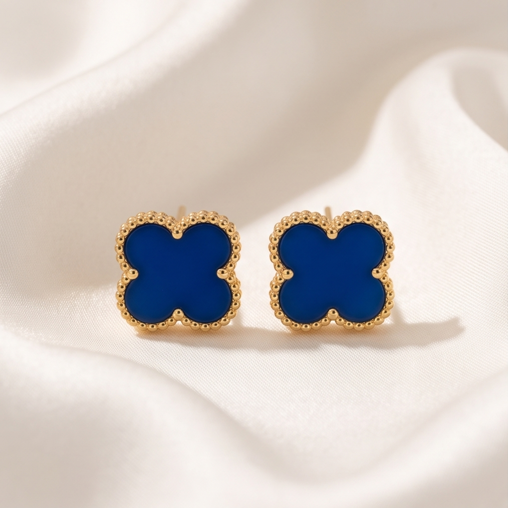 Blue clover stud earrings on white silk fabric