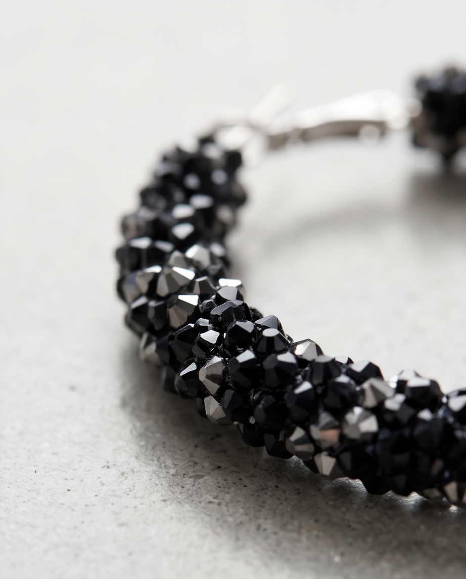 Sparkling black pavé crystal hoop earrings close-up detail showing faceted crystals and silver clasp