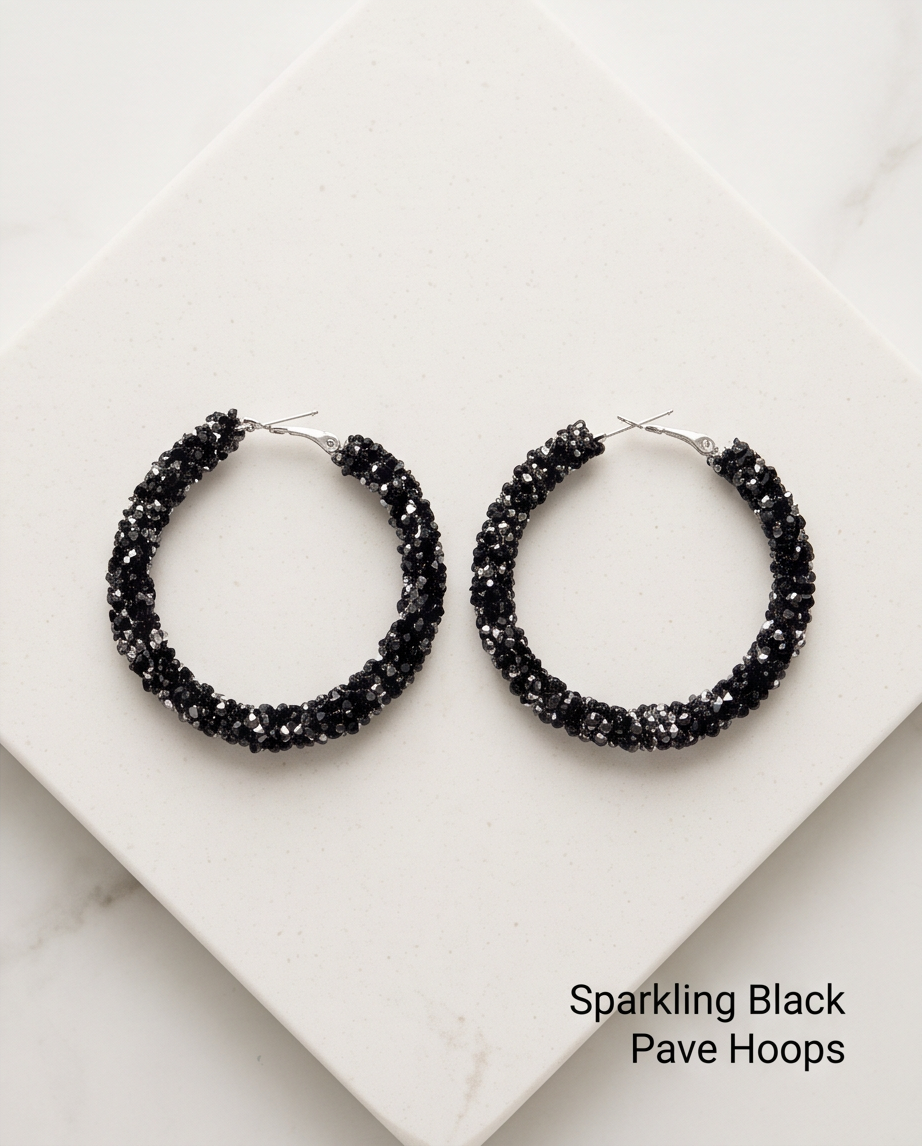 Sparkling black pavé crystal hoop earrings flat lay on white marble block
