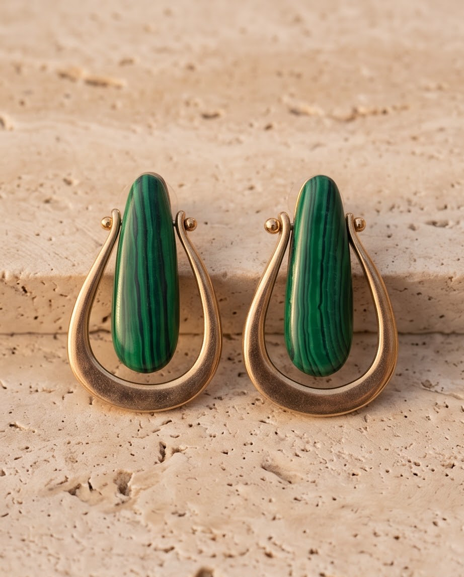 Model wearing gold tone open teardrop and malachite stone drop earrings