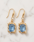 Gold Star Frame Blue Crystal Drop Earrings — flat lay on marble with hook fastening