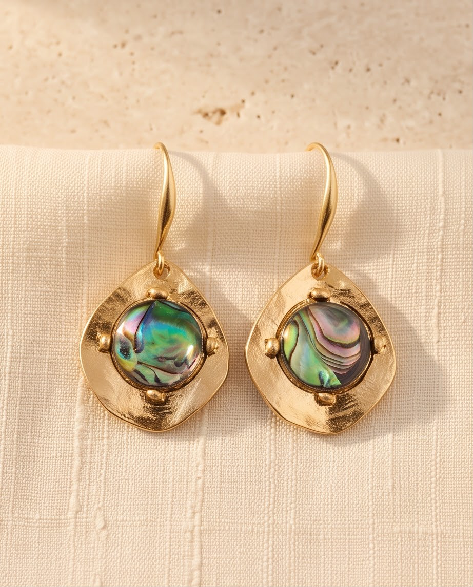 Close-up of iridescent abalone stone set in hammered gold disc earring