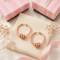 Close-up of rose gold crystal pavé knot detail on hoop earring