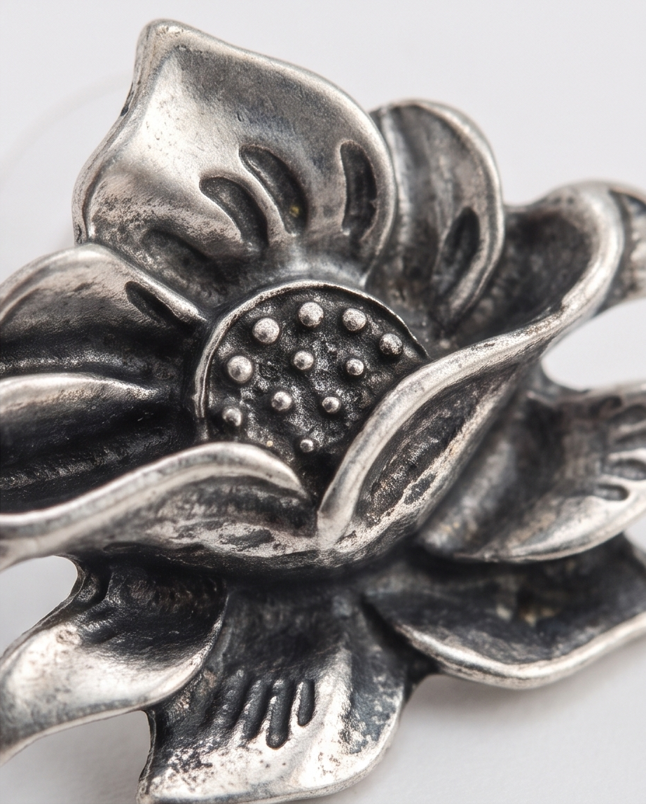 Close-up macro detail of antique silver lotus flower stud earring showing intricate petal and dot texture