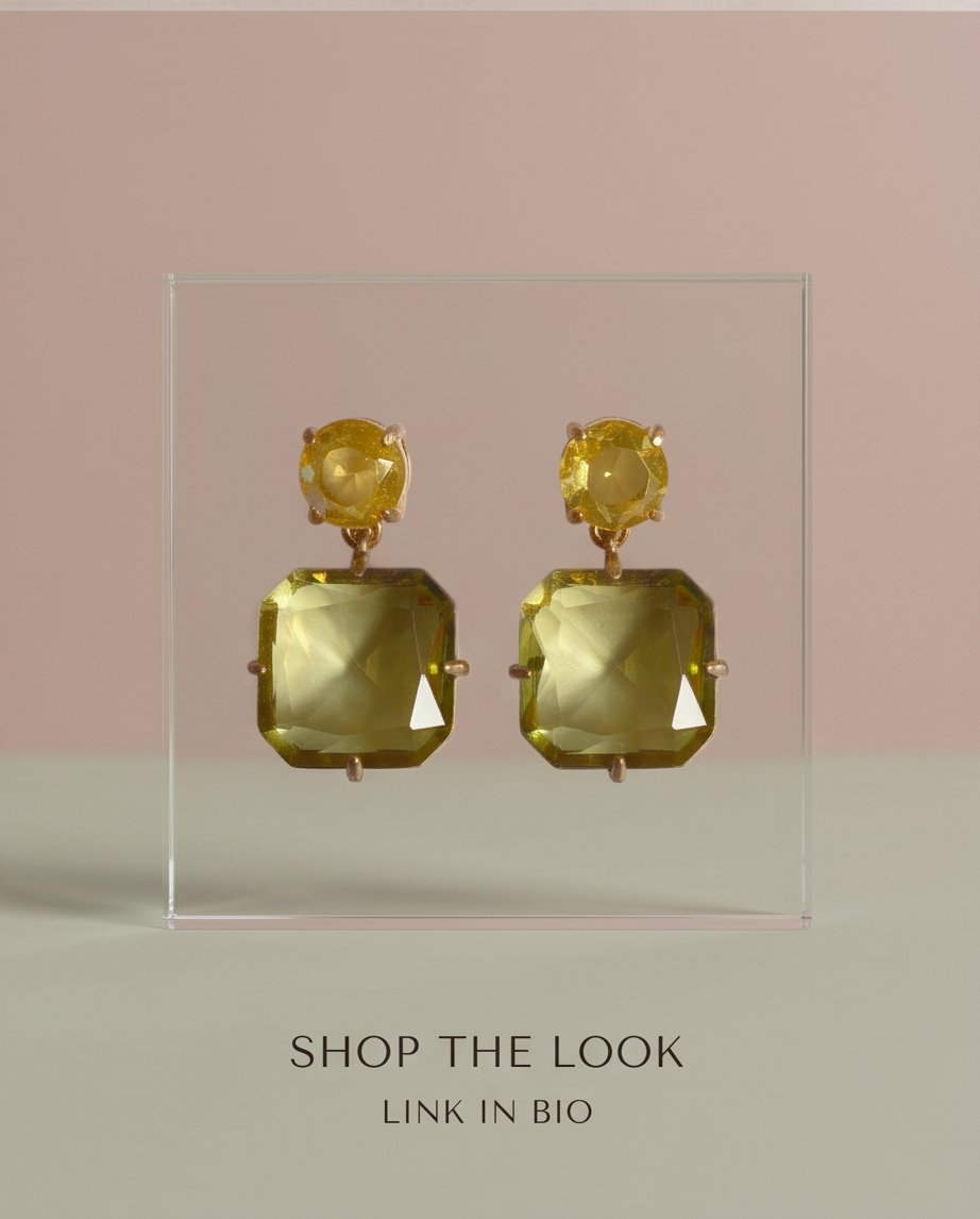Pair of gold lemon quartz crystal double drop earrings displayed on acrylic stand with shop the look text