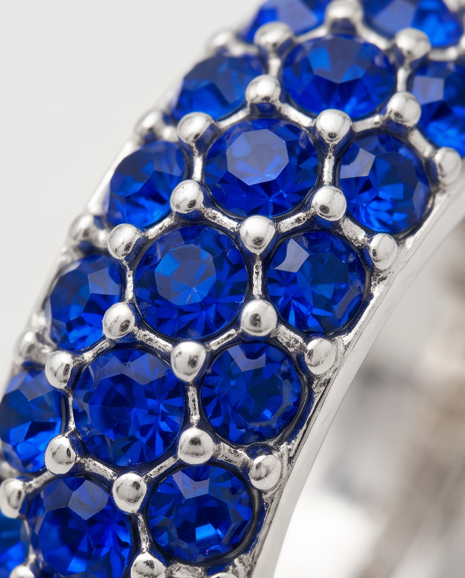 Close-up macro detail of sapphire blue crystal pavé setting on silver hoop earring