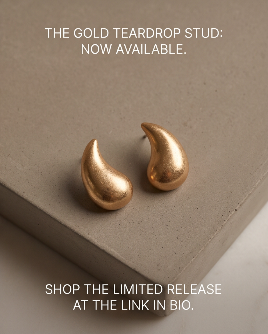 Pair of gold tone brushed chunky teardrop stud earrings on concrete step with lifestyle text overlay