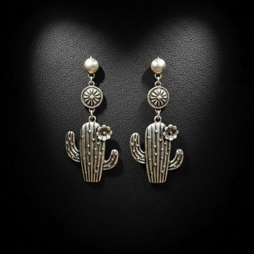Silver cactus-shaped earrings on a black background