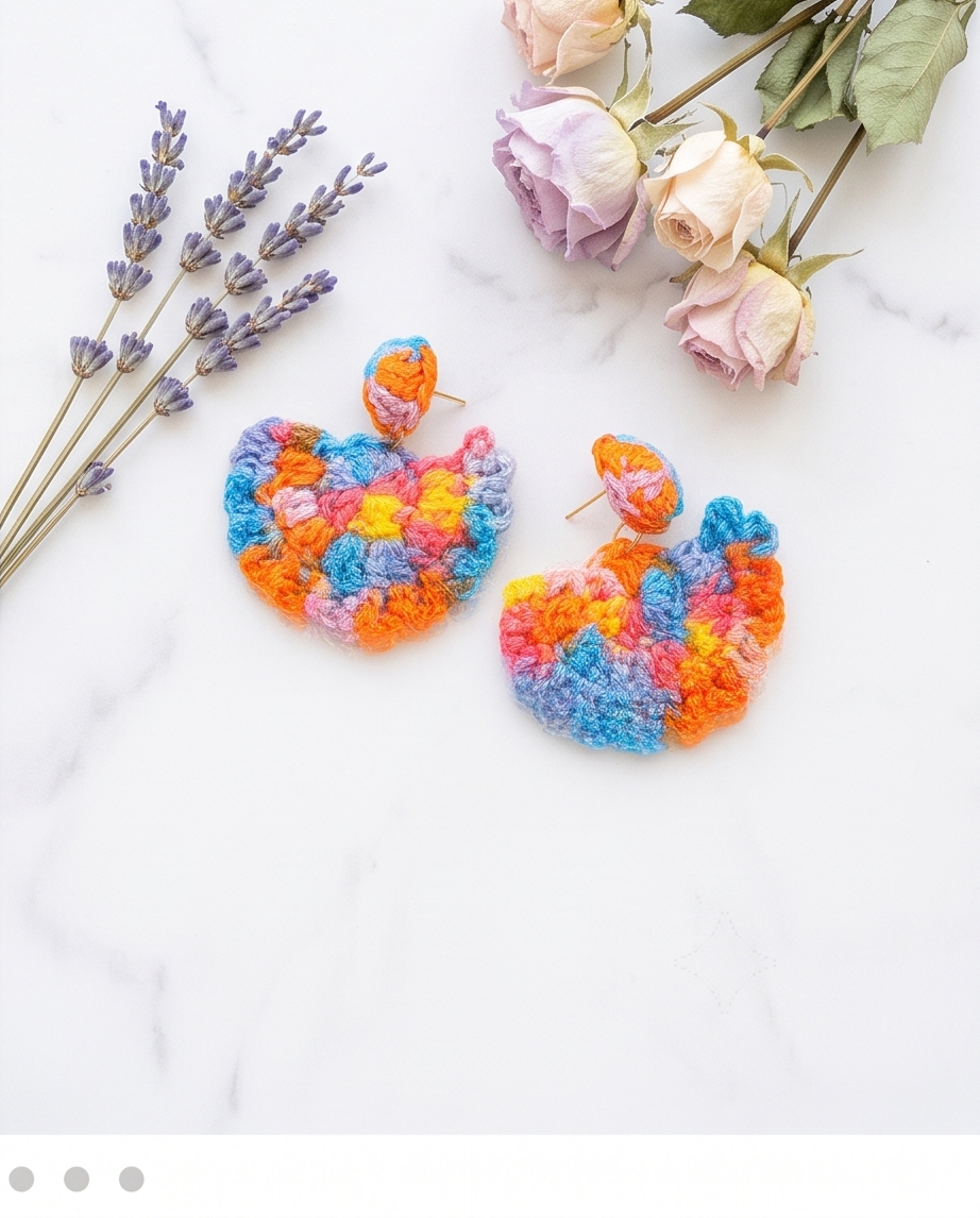 Rainbow crochet fan drop earrings flat lay on marble with lavender and roses