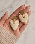 Cream marble heart drop earrings on cream silk fabric