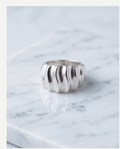 Silver wave dome ring on marble surface