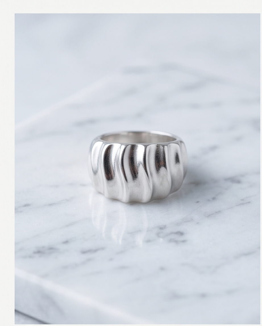 Silver wave dome ring on marble surface