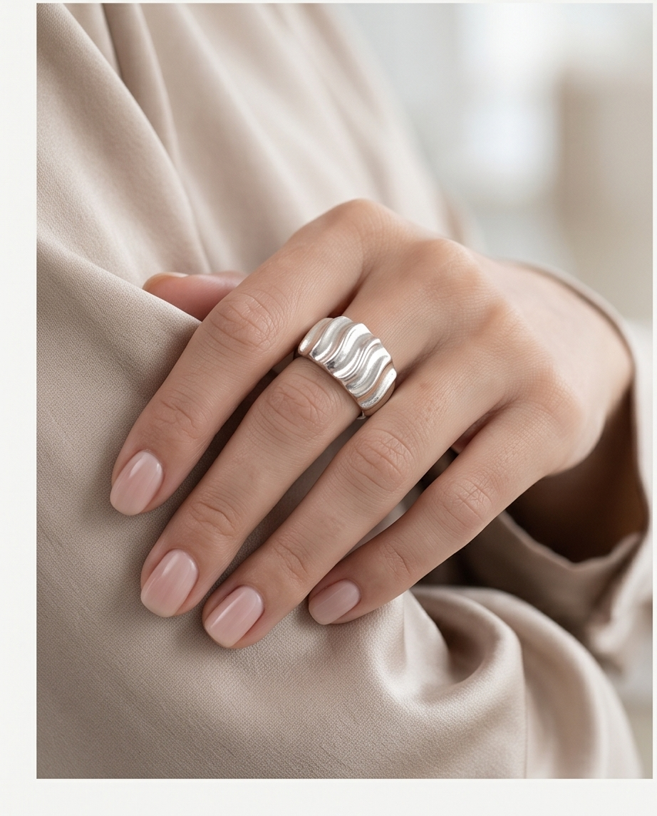 Close-up of silver wave dome ring detail
