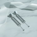 Silver oval loop drop earrings luxury staging shot on marble surface