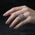 Silver Gothic Cross Lattice Wide Band Ring close-up on female hand with nude nails